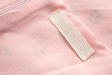 Blank laundry care clothes label on fabric texture background