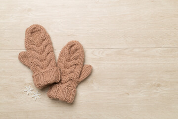 Brown winter mittens on wooden background. Top view