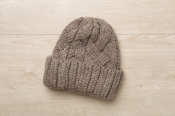 Grey winter hat on wooden background. Top view