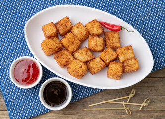 Tapioca dice, typical northeast brazilian food with chilli pepper and sugar syrup over wooden table