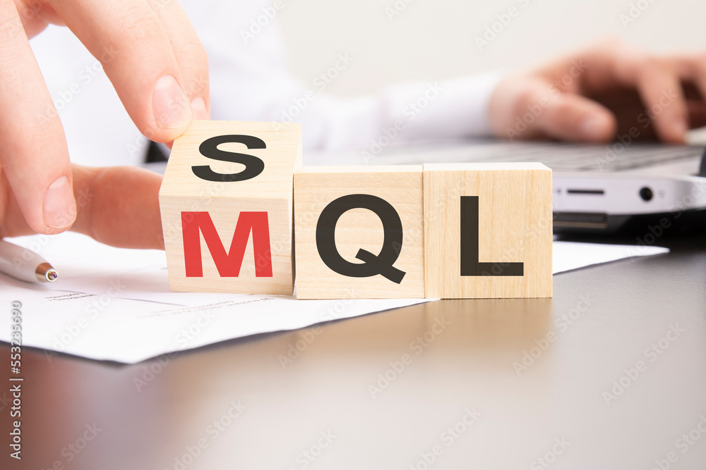 Poster sql or mql symbol. hand turns cubes and changes words 'sql sales qualified lead' to 'mql marketing q
