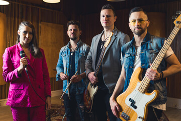 photo for a music band album cover, four members standing in the recording studio. High quality photo