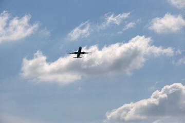 Airplane flying over blue sky and clouds