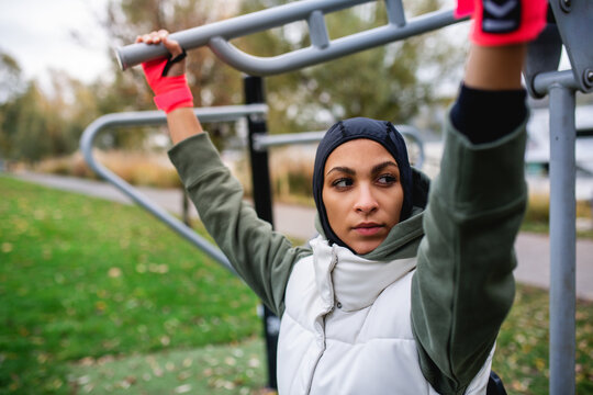 Young Muslim Woman In Sports Hijab Doing Work Out In Outdoor Training Ground.