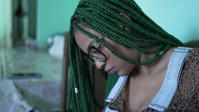 A black hispanic girl looking at smartphone device. A young latina woman scrolling through social media