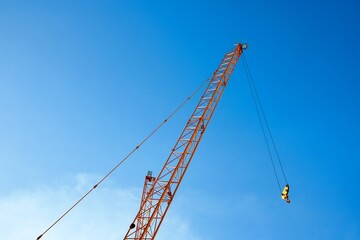 The industrial construction crane on blue sky background.