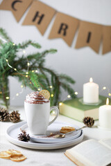 Obraz na płótnie Canvas Hot winter drink: chocolate with whipped cream in white mug. Christmas time. Cozy home atmosphere, white background. 