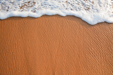 Wave surging on sand on beach. Lots of copyspace