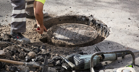operator in uniform finishes process filling electrical records urban road on asphalt