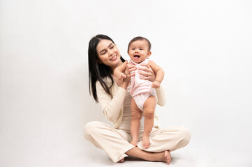 Beautiful mother and adorable baby girl are happy on white background, family, child, childhood and...