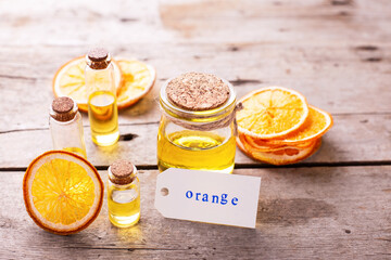 Bottles  with organic essential aroma oil  with orange on aged wooden background. Natural skin care products. Beauty blogging, salon treatment concept. Selective focus. Place for text..