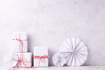 Postcard with  wrapped boxes with presents and ehandmade paper rosettas against textured  wall....
