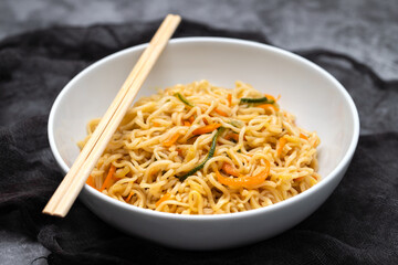 Fresh tasty noodles with vegetables in white bowl