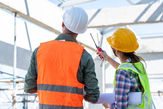 Engineering Consulting People on construction site holding blueprint in his hand. Building inspector. Construction site check drawing and business workflow of new building