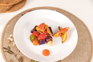 Assorted vegetables cooked in the oven and placed on a plate, ready to eat. Healthy and tasty food.