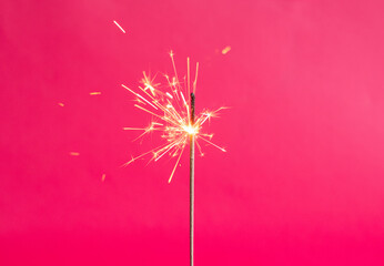Bengal lights on a pink background. Sparkler on a bright color. Copy space. Defocus festive...