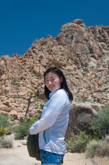 happy chinese woman standing in Joshua Tree national park