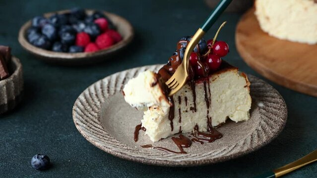 Taking a bite of cheesecake. Eating cheesecake. Piece of San Sebastian Basque Cheesecake with berries. Basque cheesecake. Popular dessert. Burnt cheesecake.