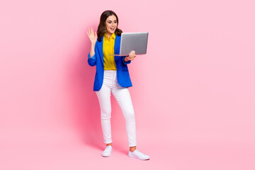 Full size photo of pretty positive girl arm waving hi video call wireless netbook isolated on pink color background