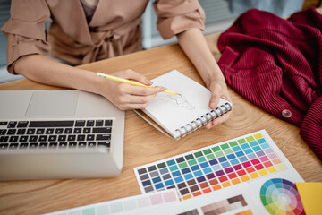 Fashion Designer Stylish Artist or creative designer drawing on sketch book with new project design.