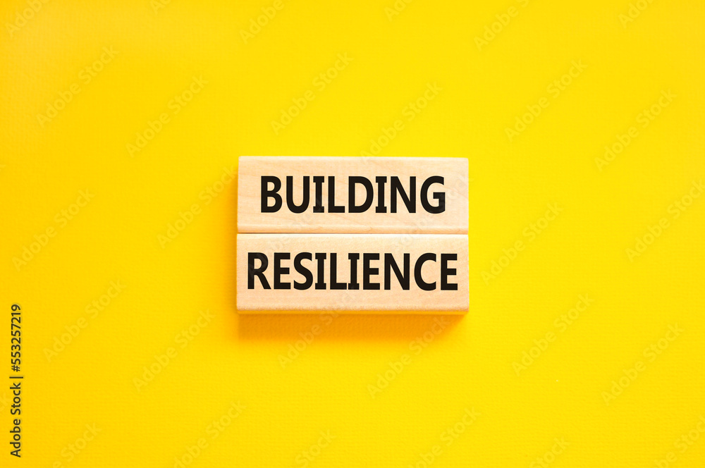 Poster building resilience symbol. concept word building resilience typed on wooden blocks. beautiful yello