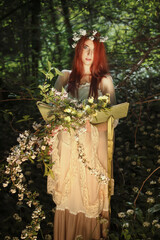 Maiden of the forest with book full of flower
