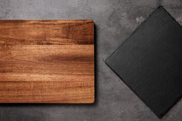 slate cutting board on a dark stone background with wooden cutting board