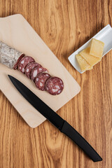 appetizer platter with salami and cheese with black knife
