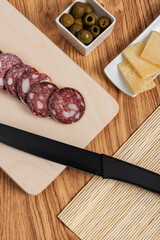 appetizer platter with salami and cheese with black knife