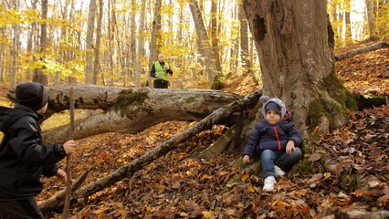 A pre-adolescent boy got lost in the autumn forest and is sitting under a tree. Search for missing children by volunteers. A family with the help of volunteers finds a missing child in the forest.