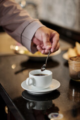 Fototapeta na wymiar Man Mixing Sugar in Coffee