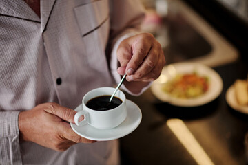 Man Mixing Sugar in Cup of Coffee