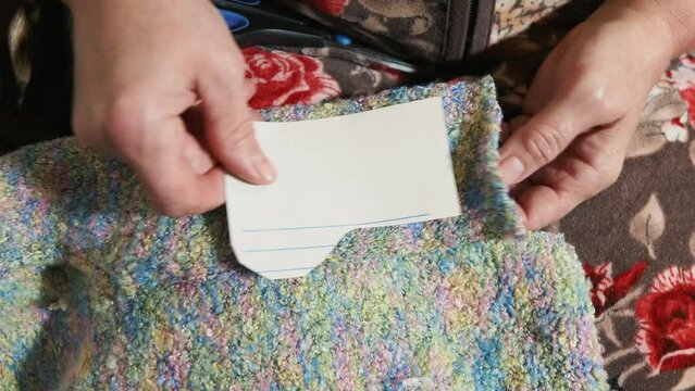 Grandma cuts out a template for New Year's socks with scissors. the active old age of the grandmother makes socks for her grandchildren with her own hands. hands of an elderly woman cutting out close-