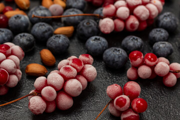 Frozen bunches of red berries and nuts.