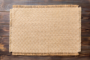 Top view of brown tablecloth for food on wooden background. Empty space for your design