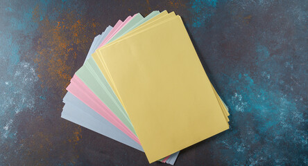 Stack of colorful paper of blue,yellow and pink paper ,top view.