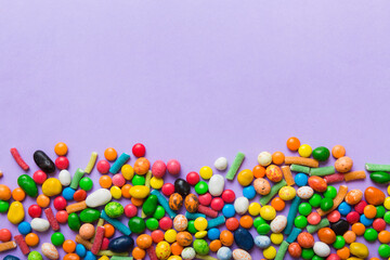 Mixed collection of colorful candy, on colored background. Flat lay, top view. frame of colorful chocolate coated candy