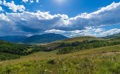 Fototapeta na wymiar Green mountain hillside with summer clouds building