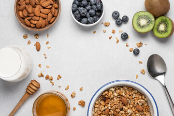 Oatmeal granola, milk, berries and fruits on light background. Ingredients for making homemade...