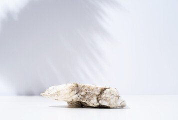 A minimalistic scene of stone marble podium on white background, for natural cosmetics