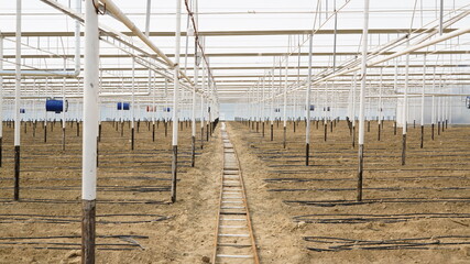 empty greenhouse with irrigation pipes