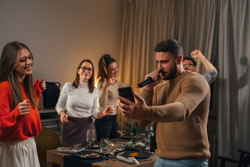 Man is singing in the microphone at a home karaoke party