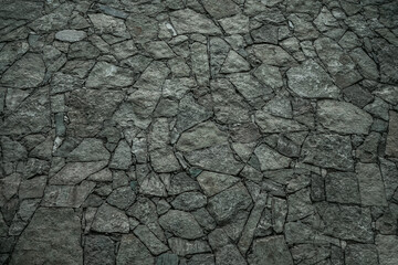 Texture of a stone wall, roads from stones, bricks, cobblestones, tiles with sandy seams of gray ancient natural grey with sharp edges. The background.