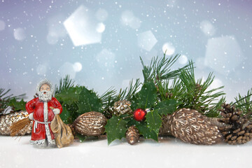 Klassischer Weihnachtsmann mit Baumkugeln, Fichtenzweigen und Dekoration im Schnee, Winterlicher Hintergrund mit Lichtreflexen und Freifläche für Text