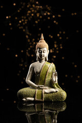 Buddha statue in meditation on black background. Vertical format.