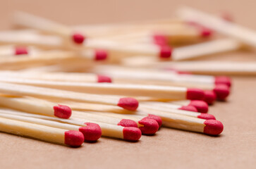 Close-up macro of a pile of new unlit wooden matchsticks on natural brown paper background