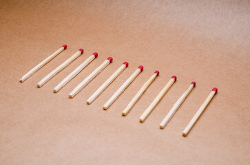 New unlit wooden matchsticks orderly aligned on natural brown background