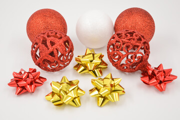 Christmas decorations with two red and white glitter balls and red and gold colored stars on a...