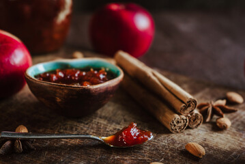 apple jam in a bowl, fresh fruits, apples, spicy spices of cinnamon, almond and anise on a brown wooden background 1