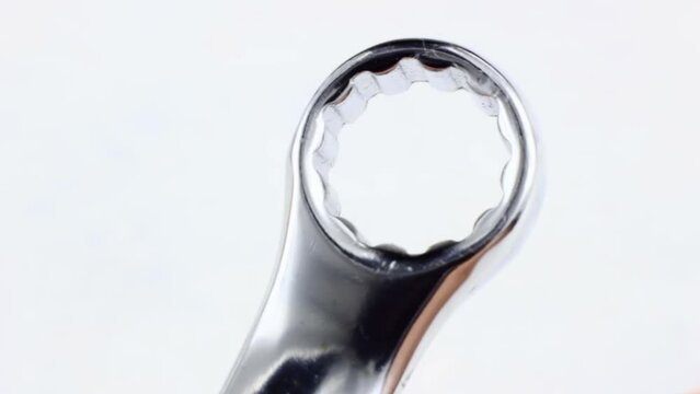 Silver metal ring spanner for maintenance turning close up on white background
